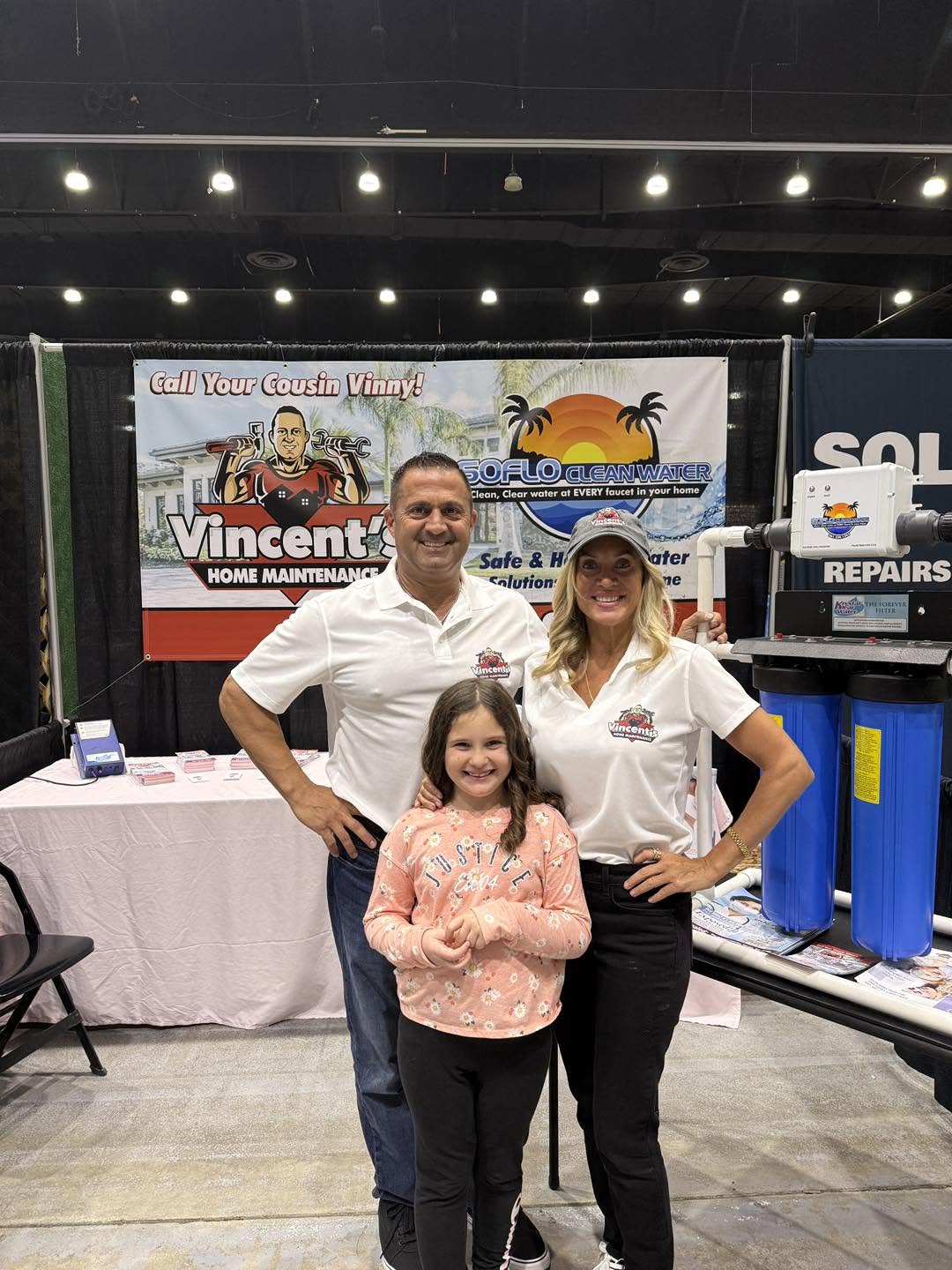 Vincent's Home Maintenance team at trade show booth with water filtration display